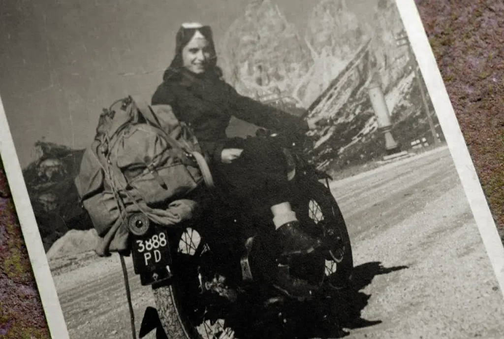 Foto vecchia di una donna con zaino in una moto